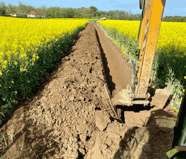 Travaux de terrassement avec pelle mécanique dans un champ à Dax